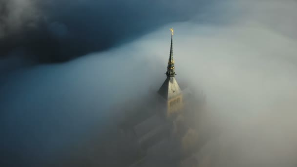 Piękne lotnicze strzał grubej mgły obejmujące mistyk starożytny zamek wschód słońca Mont Saint Michel na skraju ciemności. — Wideo stockowe