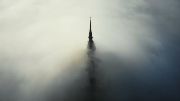 Tiro aéreo atmosférico, gruesas nubes de niebla fluyen cubriendo el famoso castillo fortaleza del Mont Saint Michel a la salida del sol . — Vídeo de stock