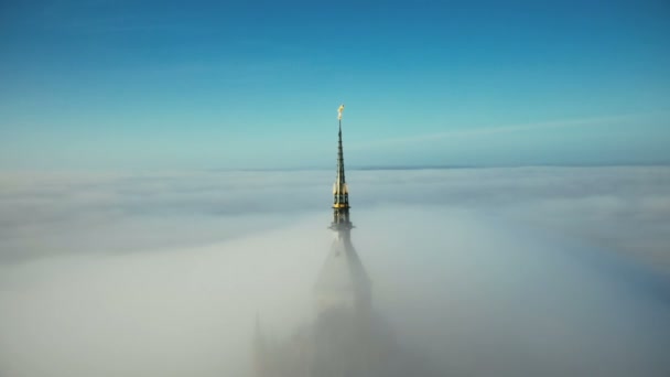 Piękne lotnicze panoramowanie strzał chwalebnej złotej iglicy w zamku Mont Saint Michel pokryte epickie Sunrise mgła chmury. — Wideo stockowe