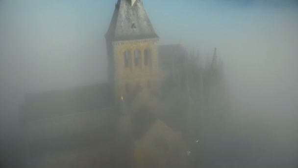 Atmospheric aerial close-up shot of mysterious Mont Saint Michel island fortress abbey under thick dark grey fog clouds. — Stock Video