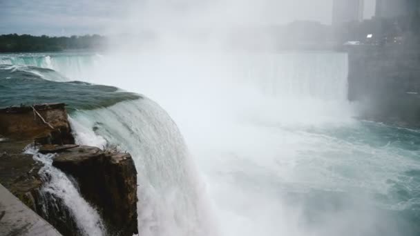 Erstaunliche Nahaufnahme eines Vogels, der durch reißenden Wasserstrom fliegt, der bei epischen Niagarafällen in Zeitlupe einen Felsen hinunterrauscht. — Stockvideo