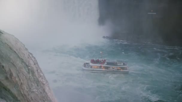 Niagarafälle 17. August 2018 epischer Blick auf Wasser, das von einem Felsen rudert, Ausflugsboot bewegt sich in der Nähe des Wasserfalls in Zeitlupe. — Stockvideo