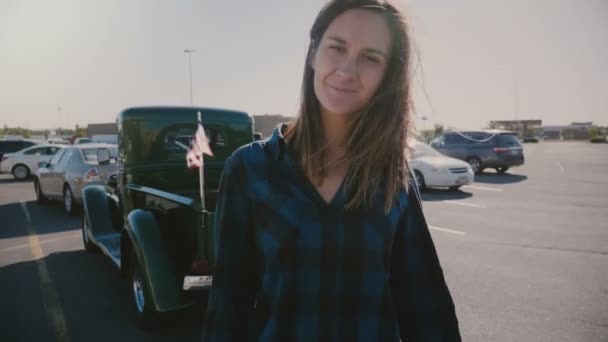 Retrato atmosférico de una joven hermosa y sonriente mujer de campo con el pelo volando en el gran aparcamiento americano de cámara lenta . — Vídeo de stock