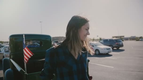 Retrato de jovem bela mulher sorridente com o cabelo soprando no vento posando no parque de estacionamento perto de captador legal câmera lenta . — Vídeo de Stock