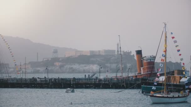 Background shot of famous Alcatraz island and former prison in San Francisco, beautiful summer cruise boats and pier. — Stock Video