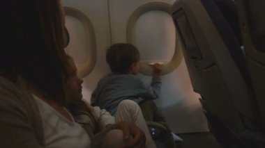 Mutlu meraklı küçük çocuk uçuş sırasında uçak pencere kapağı nı açma, aile ile tatile gidiyor görünümü zevk.
