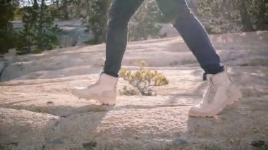 Kamera çöl ayakkabıları erkek bacaklarıkadar eğilir mutlu yerel adam güzel Yosemite orman yavaş hareket tek başına yürüyüş.