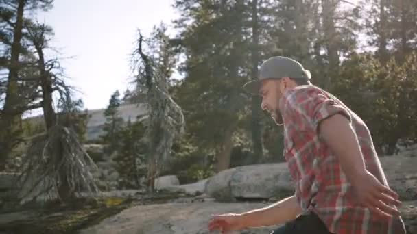 Kamera követi a fiatal boldog csinos férfi túrázás egyedül nézi kamera gyönyörű Yosemite Nemzeti Park lassított. — Stock videók