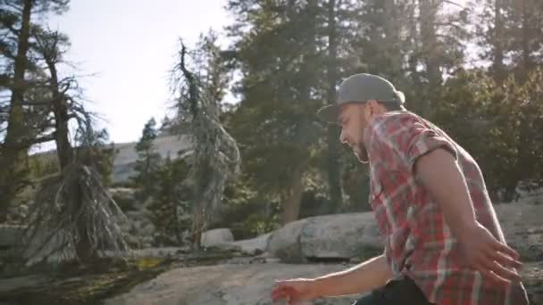 Caméra suit jeune homme heureux beau randonnée seul en regardant caméra à la belle Yosemite parc national au ralenti . — Video