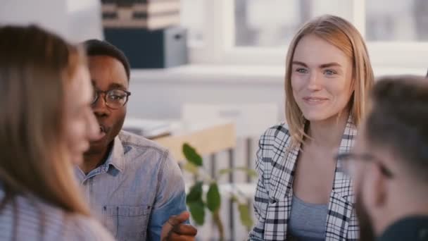 Medium shot portrait of young happy European female lawyer discussing work with mixed race business partners at meeting. — Stock Video