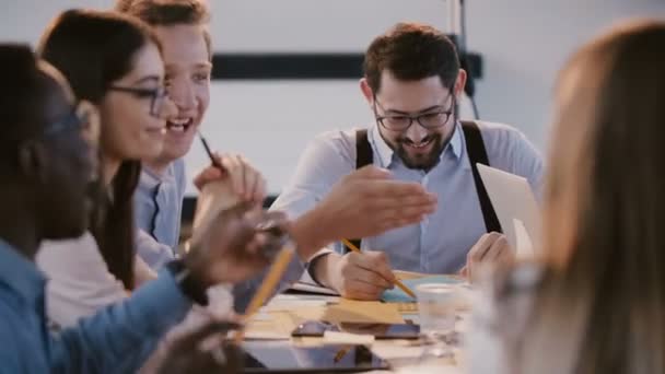 Fiatal boldog vállalati alkalmazottak csevegnek és mosolyognak a modern irodaasztalnál az üzleti szemináriumon, egészséges munkahelyen — Stock videók