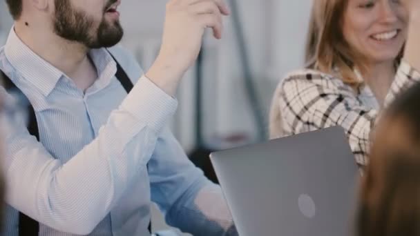 Junge, glückliche Geschäftspartner reden, diskutieren am Bürotisch während der Besprechung der Mitarbeiter am Arbeitsplatz. — Stockvideo