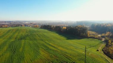 Drone sağ güneşli yeşil pastoral tarım alanı, orman yamalar ve epik gündoğumu gökyüzü altında küçük yol üzerinde kaydırma.