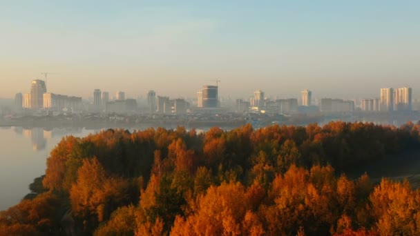 Drone acercándose al hermoso panorama del horizonte de la ciudad sobre el bosque del lago aún atardecer. Paisaje tranquilo naturaleza otoño . — Vídeos de Stock