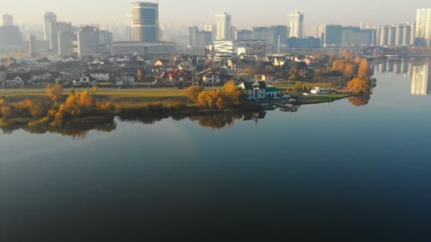 Drone naderen prachtige Sunrise stad gebouwen Panorama in Minsk, Wit-Rusland in de buurt van Still Lake water Edge reflecterende hemel. — Stockvideo