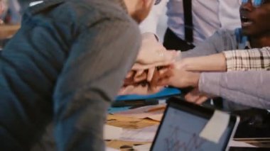 Mutlu çok ırklı iş ortaklarının yakın çekim ofis masası, takım çalışması kavramı üzerinde bir ekip olarak bir araya koymak.