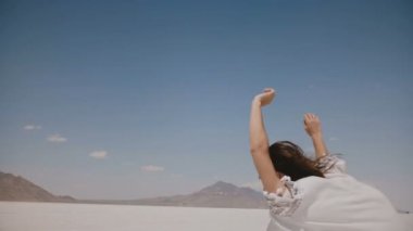 Geri görünüm güzel mutlu özgür kadın ileri kollarını açık ve uçan saç ile tuz çöl gölü Bonneville Utah çalışan.