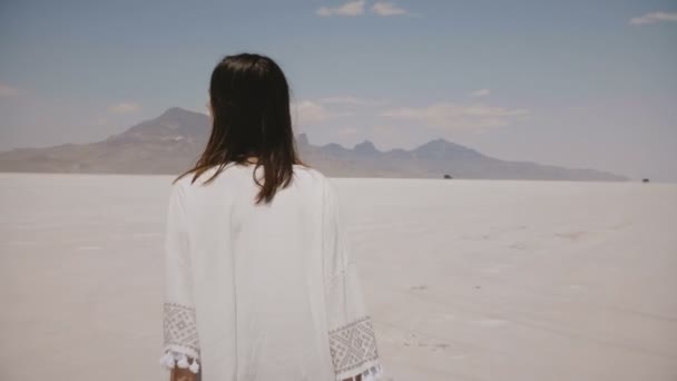 Bela jovem feliz mulher andando e girando no sol quente Bonneville sal deserto lago vestindo roupas casuais luz . — Vídeo de Stock