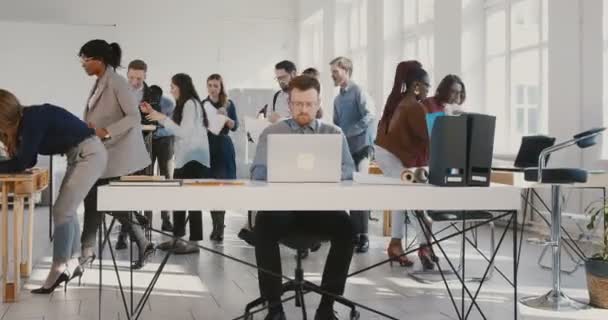 La caméra zoome sur un jeune homme d'affaires épuisé jetant des documents papier dans les airs à la table de bureau moderne occupée RED EPIC . — Video