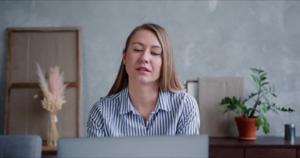 Portrait d'une jeune femme d'affaires blonde réfléchie utilisant un ordinateur portable pour travailler de la maison dans un appartement loft élégant . — Video