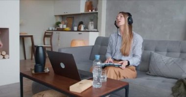 Güzel, bekar anne laptopunu kullanarak evden çalışmaya çalışıyor. Gürültülü koşan iki genç çocuk yüzünden stresli..