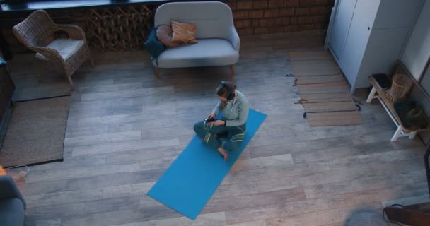 Méditation vue du dessus et soulagement du stress. Belle jeune femme sportive faisant du yoga avec application de téléphone intelligent sur l'isolement personnel . — Video