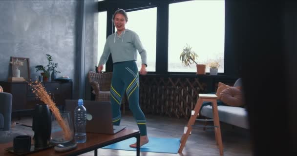 Mooie sportieve happy fitness coach vrouw toonaangevende interactieve workout sessie van thuis met behulp van laptop webcam conferentie. — Stockvideo