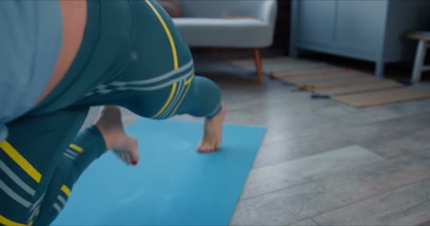Zoom arrière sur la belle jeune femme sportive qui fait de l'entraînement de fitness en sueur à la maison sur un tapis de yoga sur l'isolement de soi en quarantaine . — Video