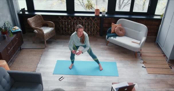 Alta angolo sportivo giovane attraente allenatore di yoga donna che lavora fuori, esercizi di streaming online utilizzando il computer portatile in quarantena . — Video Stock