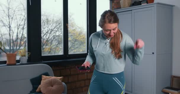 Feliz hermosa deportista entrenador de fitness mujer hablando con la cámara, mostrando el ejercicio de salto en la webcam clase de vídeo desde casa . — Vídeo de stock