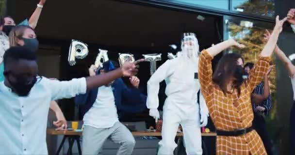 Incredibile festa di festa dopo la fine della quarantena di Covid-19. Amici danzano in costumi di sicurezza sotto coriandoli slow motion. — Video Stock