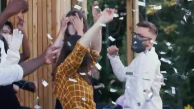 COVID-19 partisinde maskeli konfeti altında eğlendikten sonra normal hayata dönmeyi kutlayan arkadaşlar..