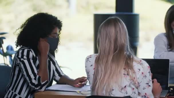 Sécurité pandémique au bureau moderne. Une équipe de jeunes gens d'affaires multiethniques heureux travaillent à la table de réunion masques. — Video