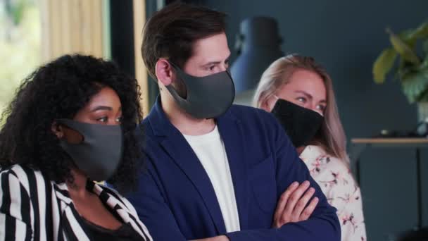 Vue de côté heureux succès jeunes collègues d'affaires multiethniques se tiennent ensemble posant dans des masques médicaux au bureau moderne — Video