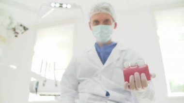 Doktor diş hekimi diş düzenini elinde tutuyor