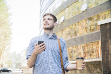 Şehirde yürüyüş sahip ve sokakta telefonda konuşurken sms işadamı yazarak mutlu adam