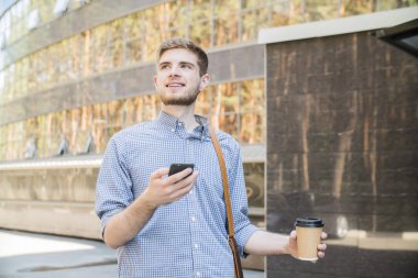 Şehirde yürüyüş sahip ve sokakta telefonda konuşurken sms işadamı yazarak mutlu adam