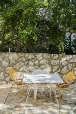 Beyaz masa sandalye kayalık duvar ve yeşil zemin üzerine ile
