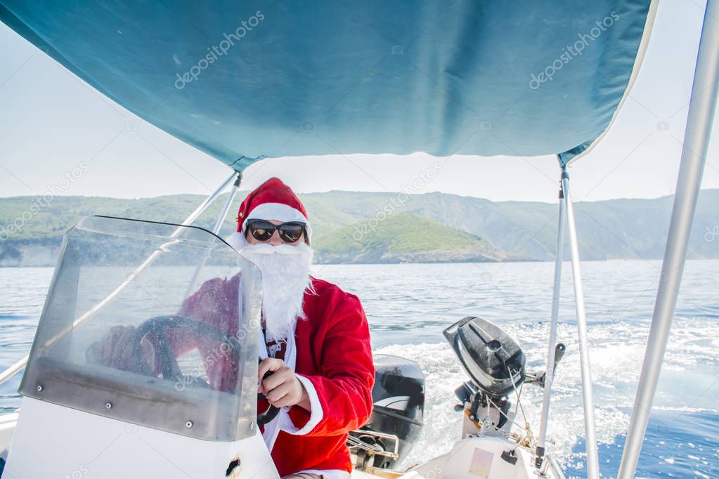 Santa Claus driving a boat on the sea