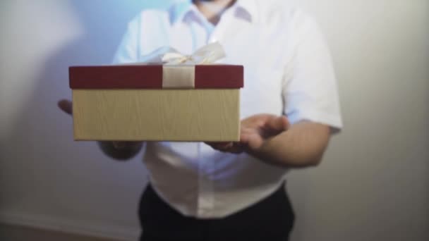 Ένας Νεαρός Άνδρας Τεντώνει Και Δίνει Ένα Κουτί Ένα Δώρο — Αρχείο Βίντεο