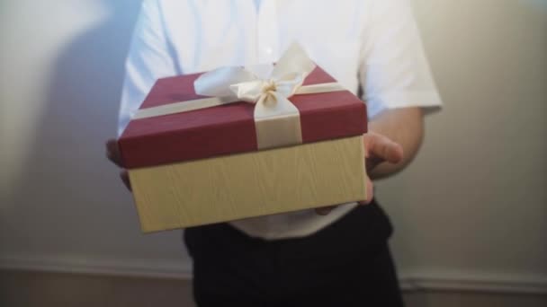 Ένας Νεαρός Άνδρας Τεντώνει Και Δίνει Ένα Κουτί Ένα Δώρο — Αρχείο Βίντεο