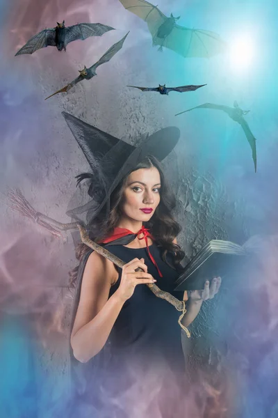 Ведьма Хэллоуин Держит Книгу Летучими Мышами Туманном Фоне — стоковое фото