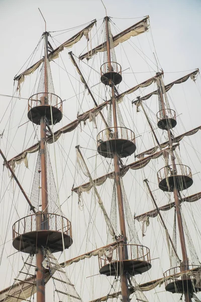 Ship big masts on cloudy sky background