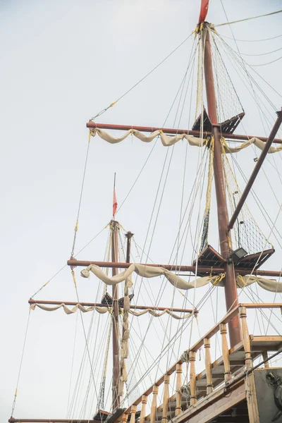 Ship big masts on cloudy sky background