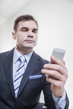 Telefonla yazarak takım elbiseli yakışıklı işadamı