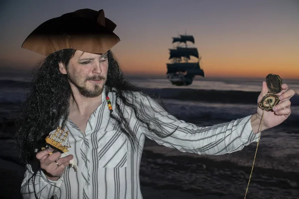 Portrait of handsome male pirate on the background of the evening sea as a symbol of tourism and travel