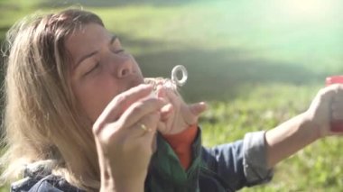 Güneşli bir günde yeşil çim arka planda anne ve oğlu