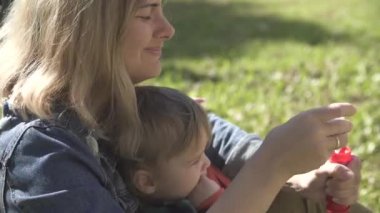 Güneşli bir günde yeşil çim arka planda anne ve oğlu