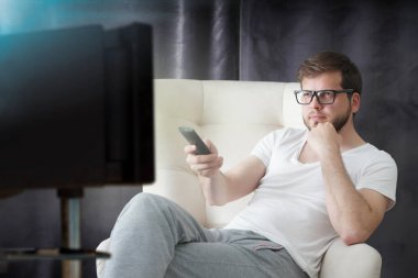 uzaktan kumanda tutan ve evde oturan Great Tv show Tv izlerken adam