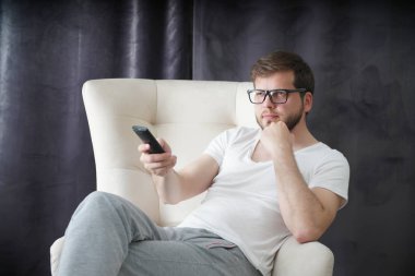 uzaktan kumanda tutan ve evde oturan Great Tv show Tv izlerken adam